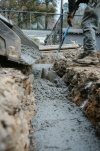 A homeowner inspects an uneven sidewalk with visible height differences between adjacent concrete slabs.